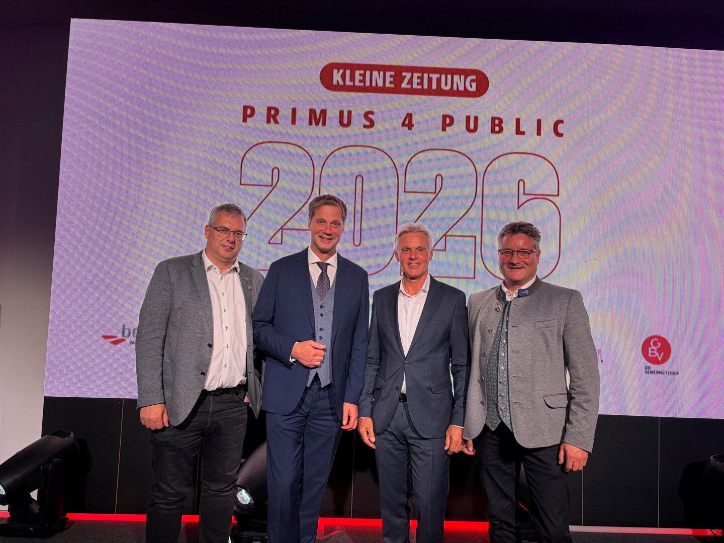 Primus 4 Public 2026: Vier Männer stehen vor einer Großbildleinwand mit dem Logo der Kleinen Zeitung.