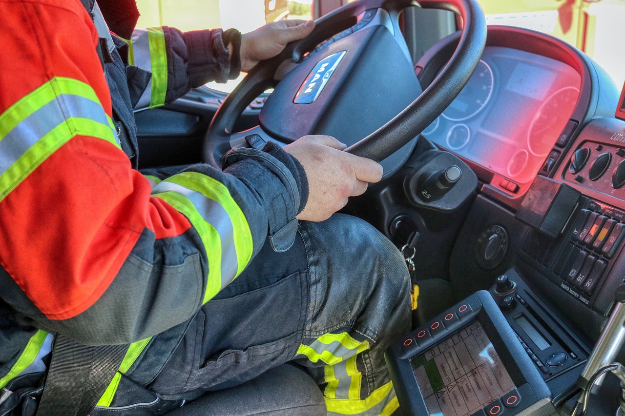 Feuerwehrmann am Steuer eines MAN-LKW mit Warnschutzkleidung im Führerhaus
